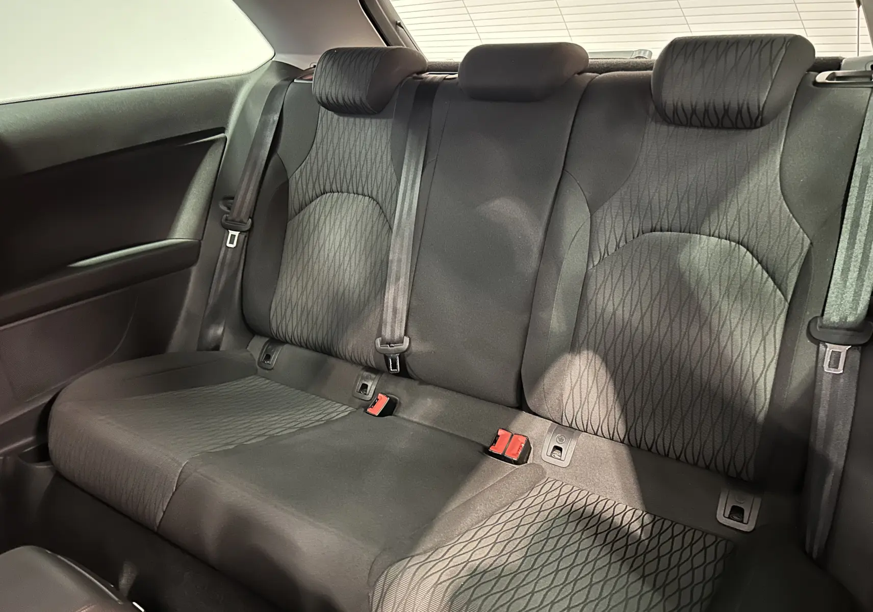 Vue intérieure arrière de la banquette arrière noire en tissu avec motifs géométriques d'une SEAT Leon 2014.