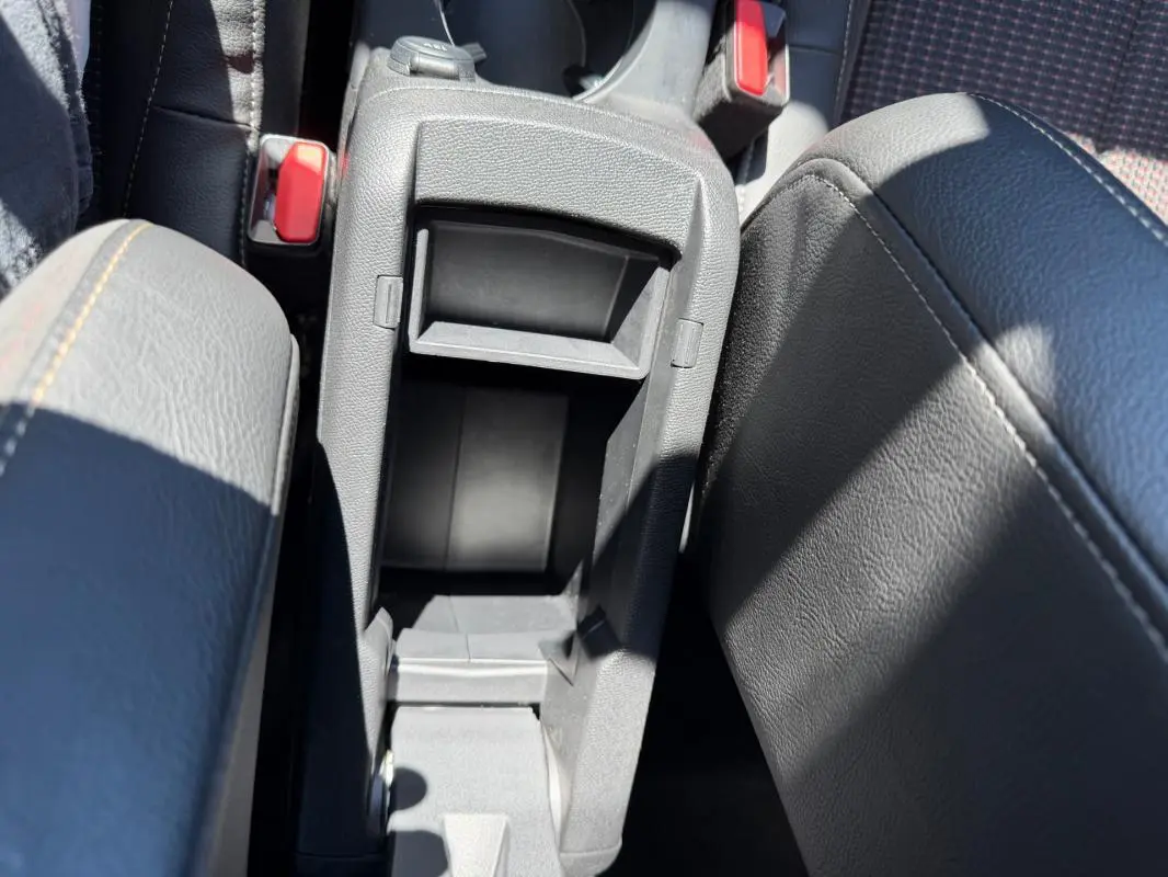 Vue plongeante sur la console centrale grise ouverte du DS3 100 BVM6 Performance Line 2024, avec accoudoirs en cuir noir.