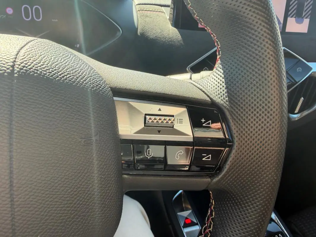 Gros plan sur le volant perforé avec commandes intégrées du DS3 100 BVM6 Performance Line gris, intérieur 2024.
