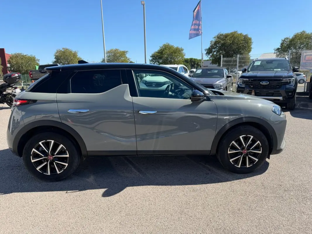 Vue de profil côté gauche d'un DS3 gris 2024 avec toit noir et jantes alliage distinctives en étoile.