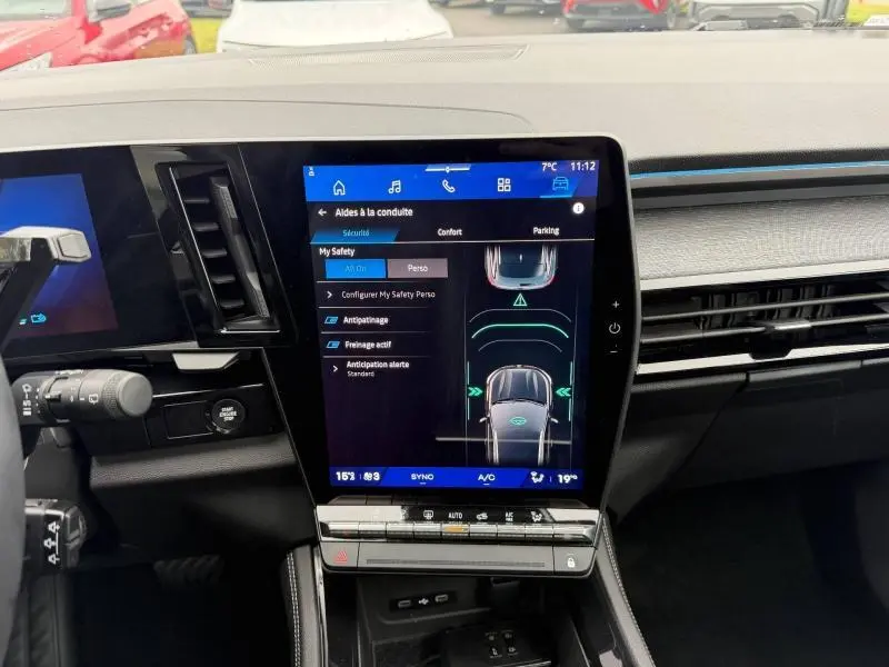 Vue intérieure du tableau de bord du Renault Austral 2025 avec écran tactile central affichant les aides à la conduite.