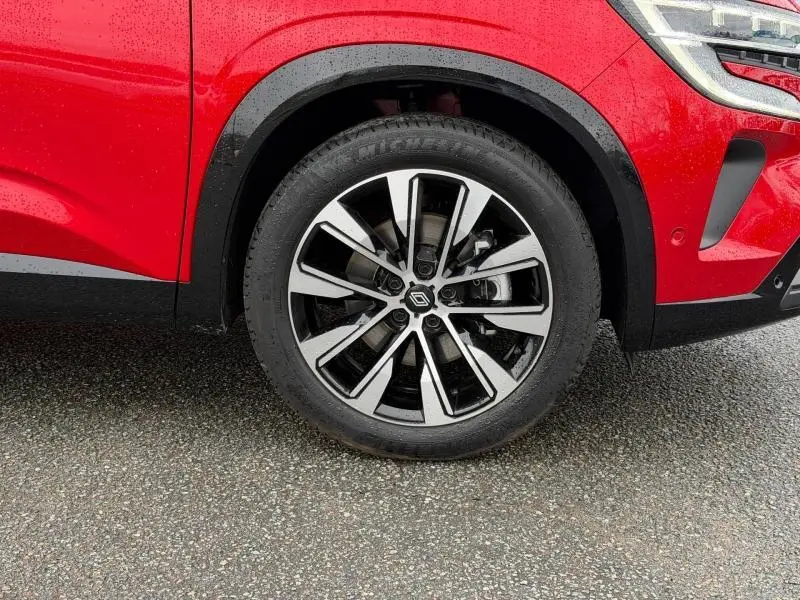 Gros plan sur la roue avant droite du Renault Austral 2025 rouge flamme, avec jante alliage au design moderne.