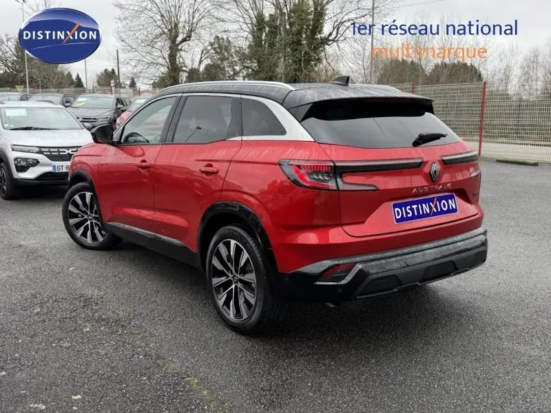 Vue 3/4 arrière droite du Renault Austral 2025 rouge Flamme avec toit noir et jantes alliage distinctives.