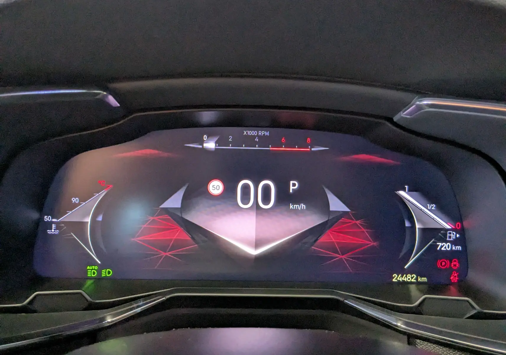 Vue rapprochée du tableau de bord numérique du DS7 gris laqué, affichant la vitesse à 0 km/h et divers indicateurs lumineux.