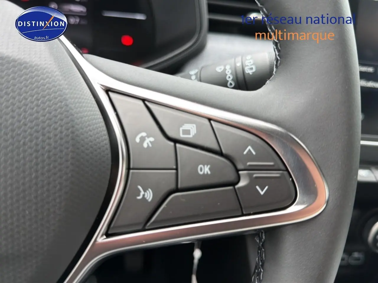 Gros plan sur les commandes multifonctions noires du volant de la Renault Clio V gris schiste, côté gauche.
