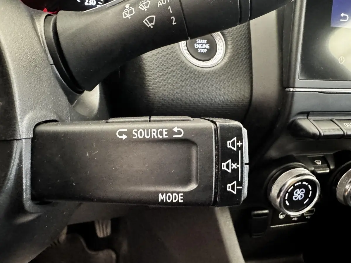 Gros plan sur la commande au volant gauche d’une Renault Clio Business TCe 90 2020, avec bouton source et mode.