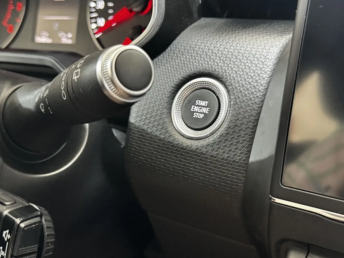 Détail intérieur montrant le bouton Start Engine Stop sur tableau de bord texturé noir de Renault Clio gris clair.
