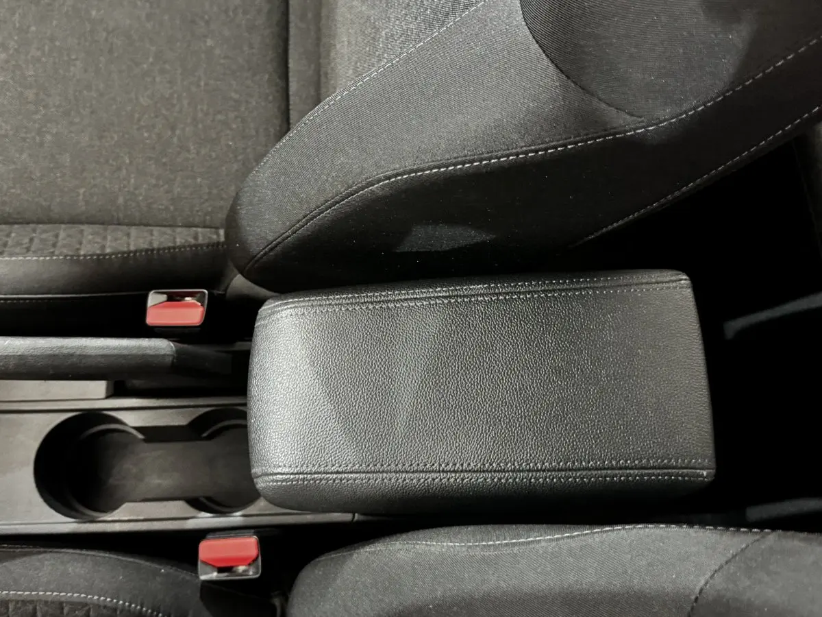 Vue rapprochée de l'accoudoir central en cuir noir entre les sièges avant gris foncé de la Renault Clio Business TCe 90 2020.