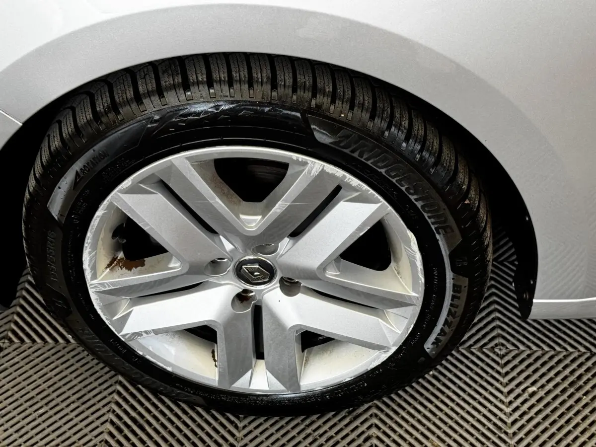 Gros plan sur la roue avant droite gris clair d’une Renault Clio Business TCe 90 avec jante alliage et pneu Bridgestone.
