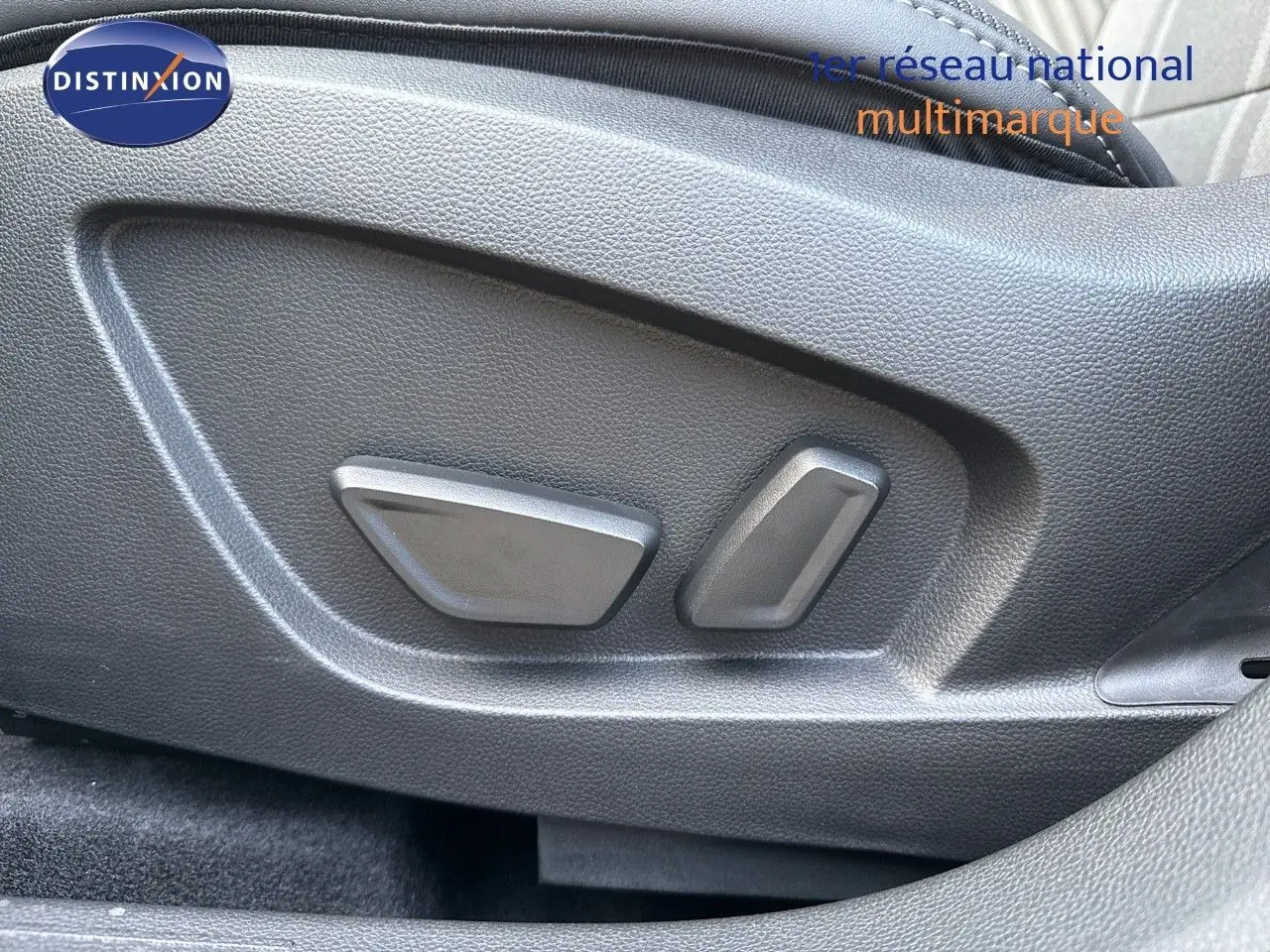Gros plan sur les commandes électriques du siège avant d'une Renault Symbioz gris cassiopée métal, version hybride 2024.