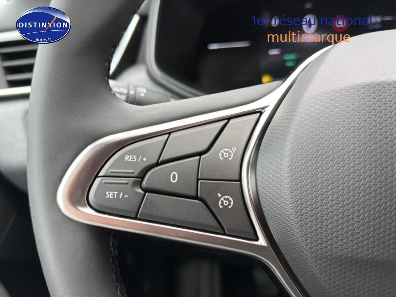 Gros plan sur les commandes du régulateur de vitesse au volant d'une Renault Clio V noire, intérieur moderne.