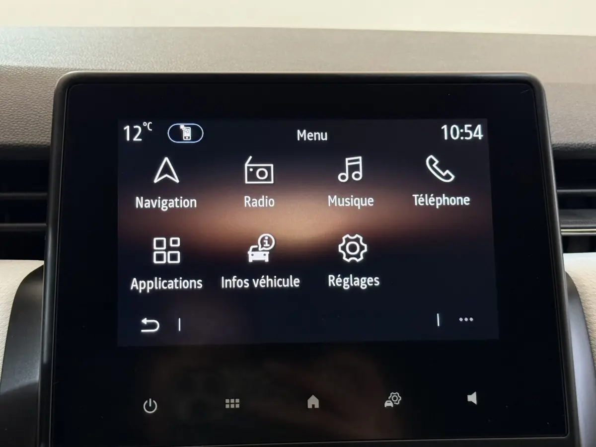 Écran tactile central de la Renault Clio blanc 2023 affichant le menu principal avec navigation et radio.