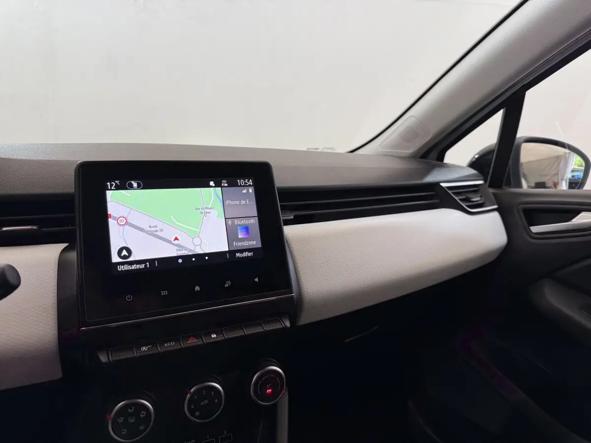Tableau de bord de Renault Clio Evolution TCe 100 GPL 2023, vue côté passager avec écran tactile de navigation allumé.