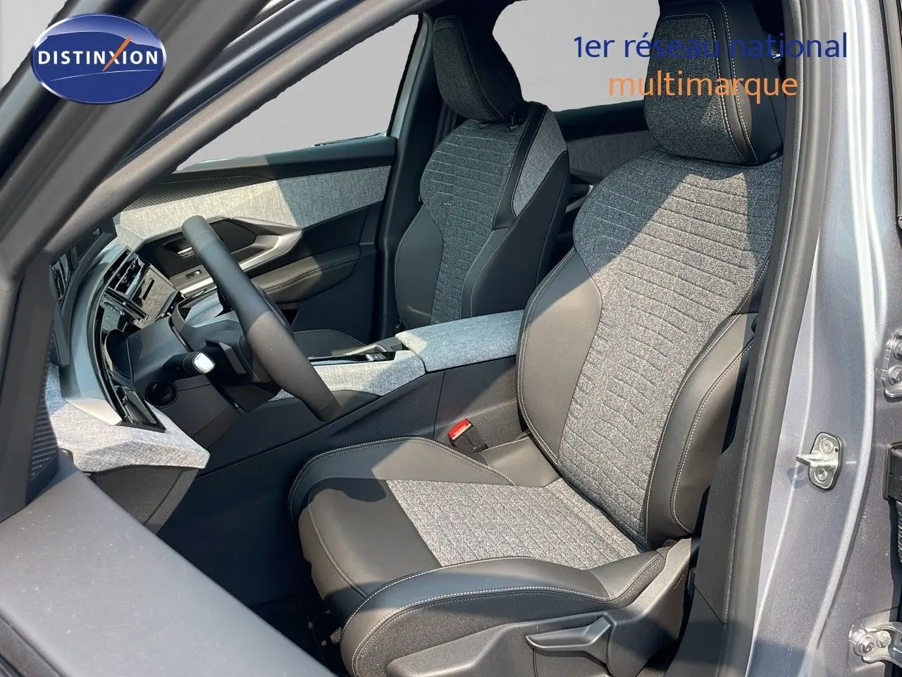 Intérieur avant droit du Peugeot 3008 Hybrid 2025 gris Artense, sièges tissu et cuir noir avec console centrale assortie.
