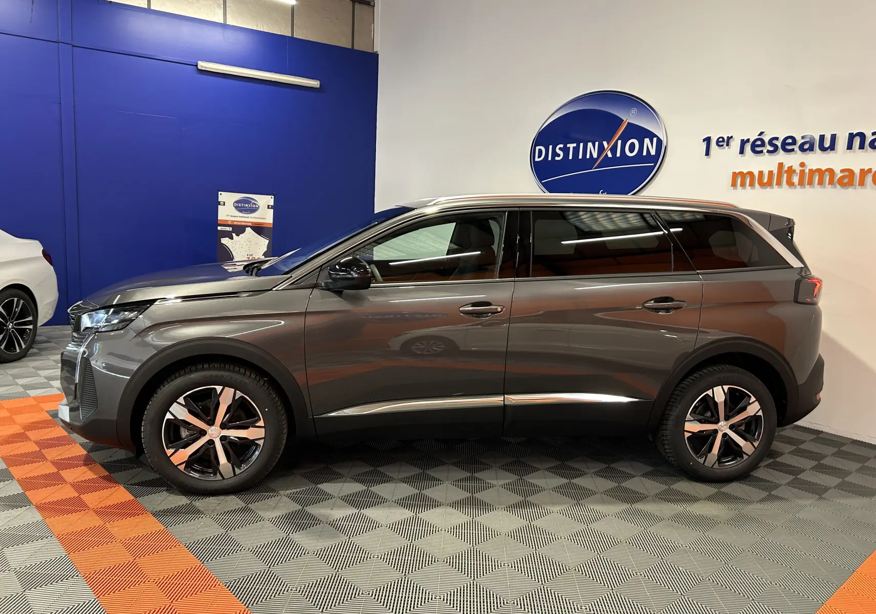 Peugeot 5008 BlueHDi 130 gris Platinium vue de profil côté gauche en intérieur showroom avec jantes bi-ton.