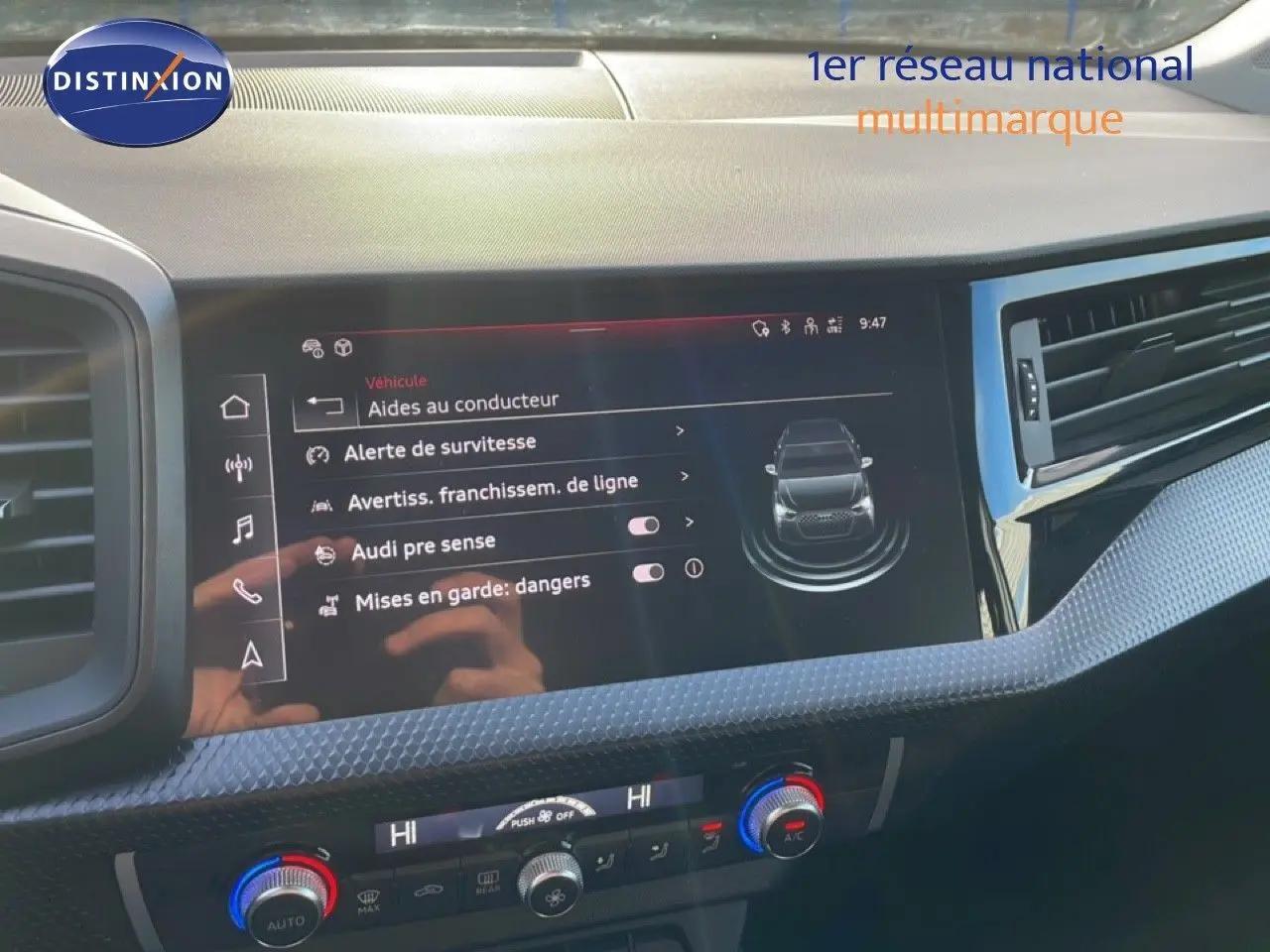 Vue rapprochée de la console centrale d'une Audi A1 Sportback blanche, montrant les commandes et ports USB.