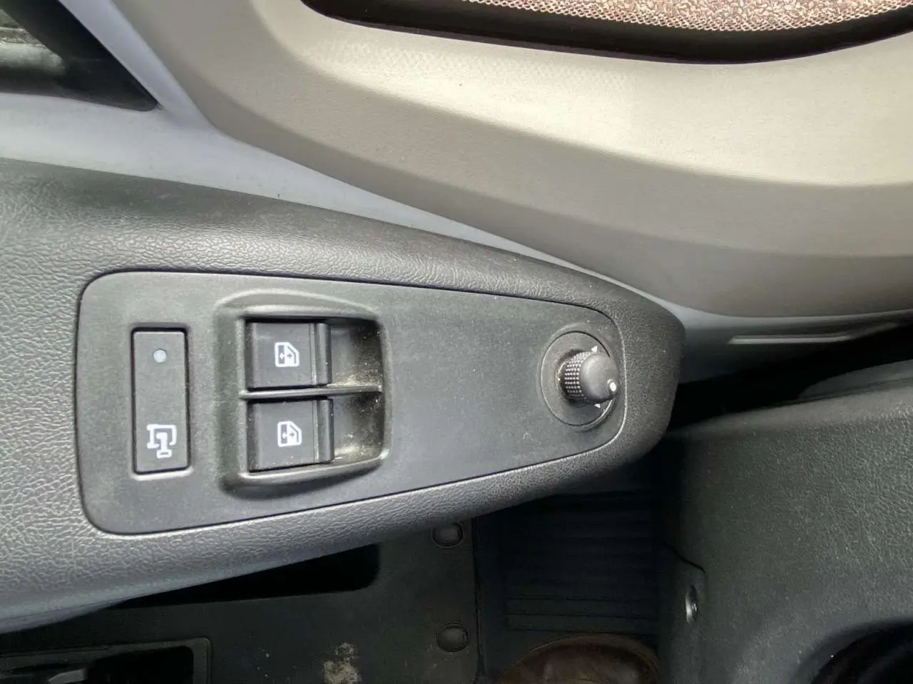 Gros plan sur les commandes de lève-vitres et réglage des rétroviseurs côté conducteur de l’Opel Movano Fourgon blanc.
