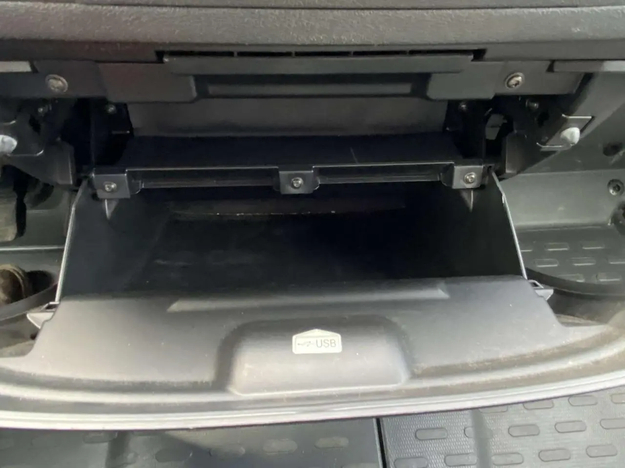 Gros plan sur la boîte à gants ouverte avec port USB visible dans l'habitacle d'un Opel Movano blanc.