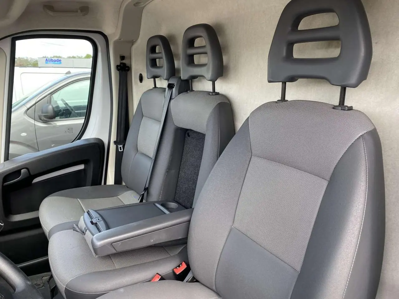 Vue intérieure côté gauche montrant les sièges avant gris du fourgon Opel Movano 2022 avec accoudoir conducteur.
