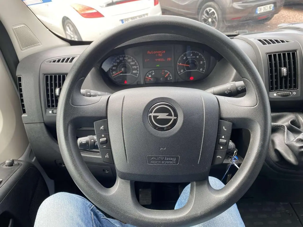 Vue intérieure centrée sur le volant noir d'un Opel Movano Fourgon 2022 avec levier de vitesses manuel à droite.