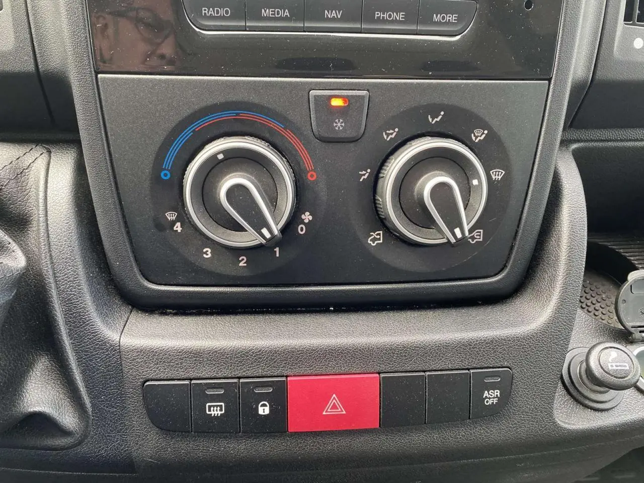 Gros plan sur la console centrale de l’Opel Movano Fourgon 2022, avec commandes de climatisation manuelle et boutons de sécurité.
