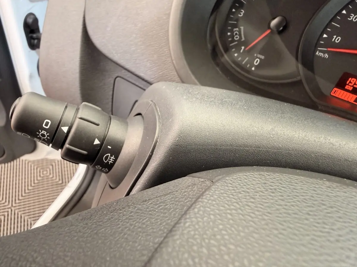 Gros plan sur la commande des phares et clignotants côté gauche du tableau de bord du Renault Kangoo blanc 2016.