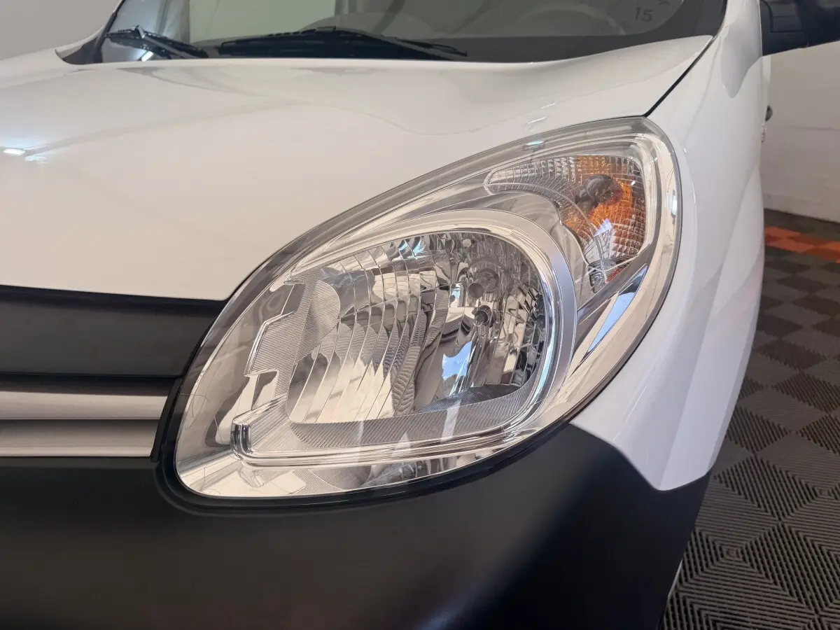 Gros plan sur le phare avant droit blanc d’un Renault Kangoo Confort Energy dCi 75 E6, avec calandre noire visible.