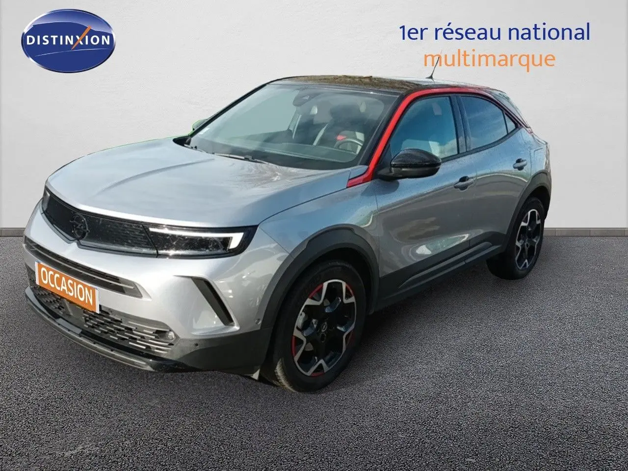 Opel Mokka GS Line gris quartz en 3/4 avant droit avec toit noir et détails rouges sur les jantes et montant de porte.