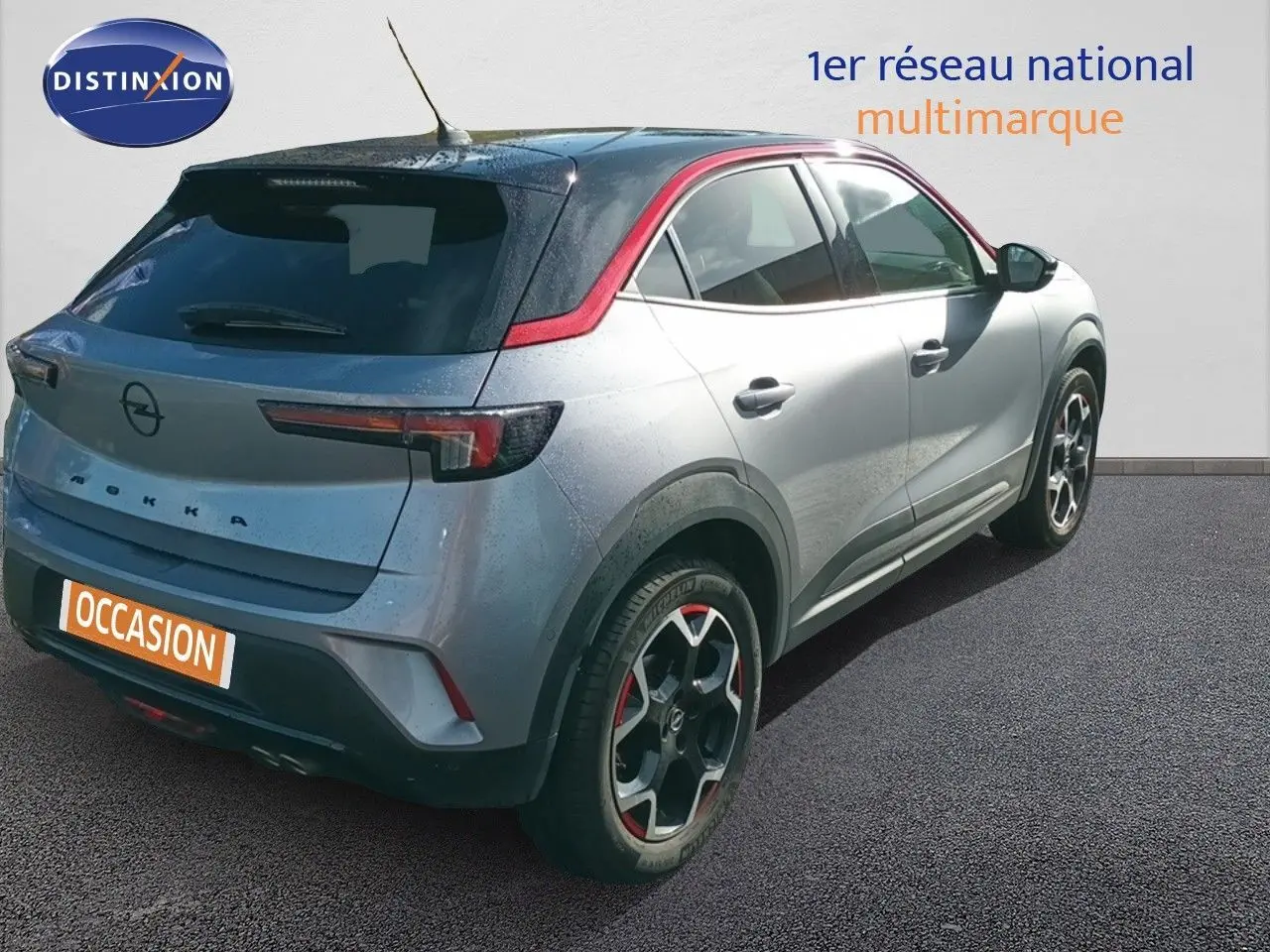 Vue 3/4 arrière droite de l'Opel Mokka GS Line 130ch BVA8 gris quartz avec toit noir et jantes bi-ton rouges.