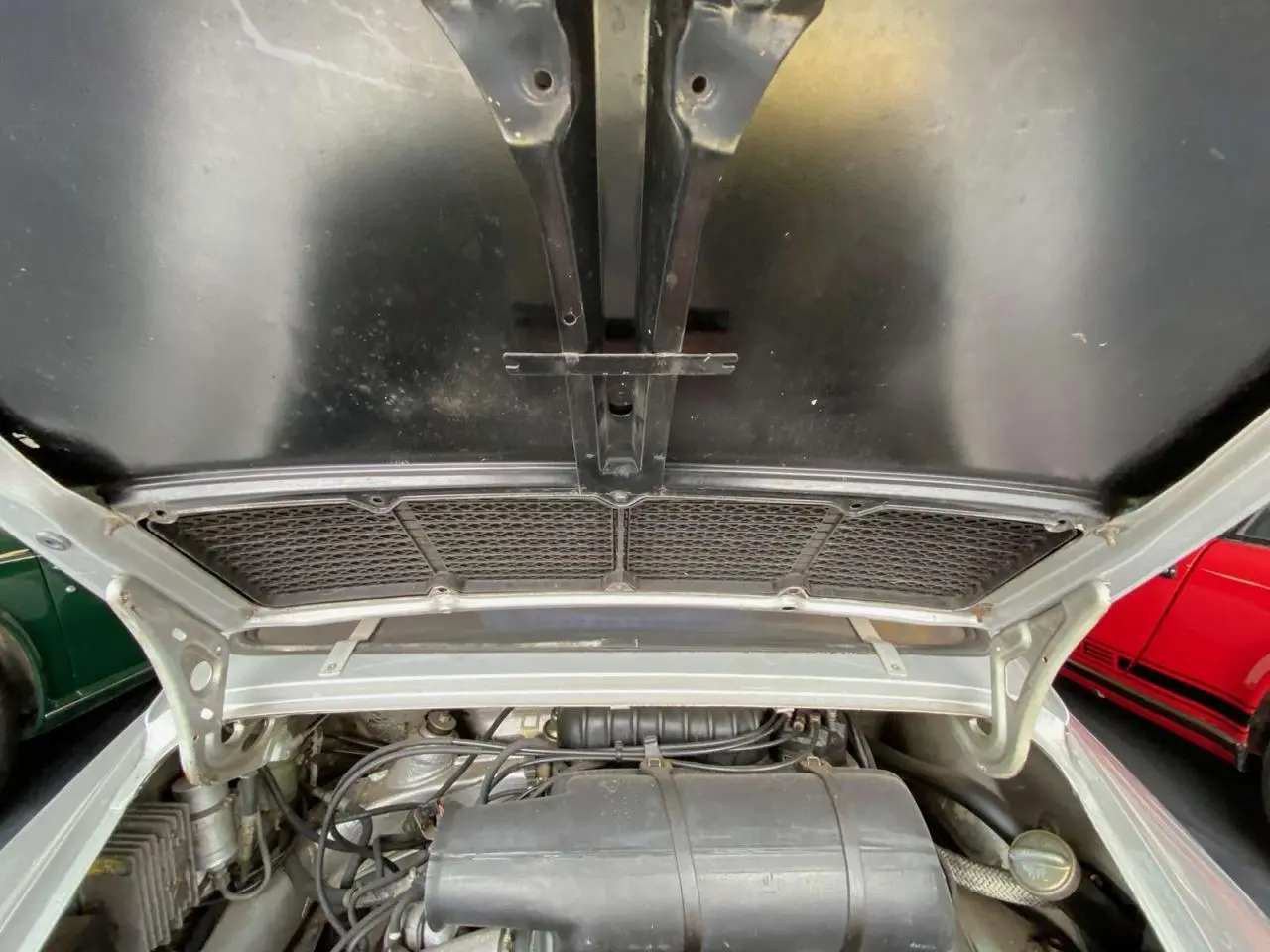 Vue plongeante sur le moteur gris d'une Porsche 911 3.0 SC 930 Kg, capot arrière ouvert en gris métallisé.