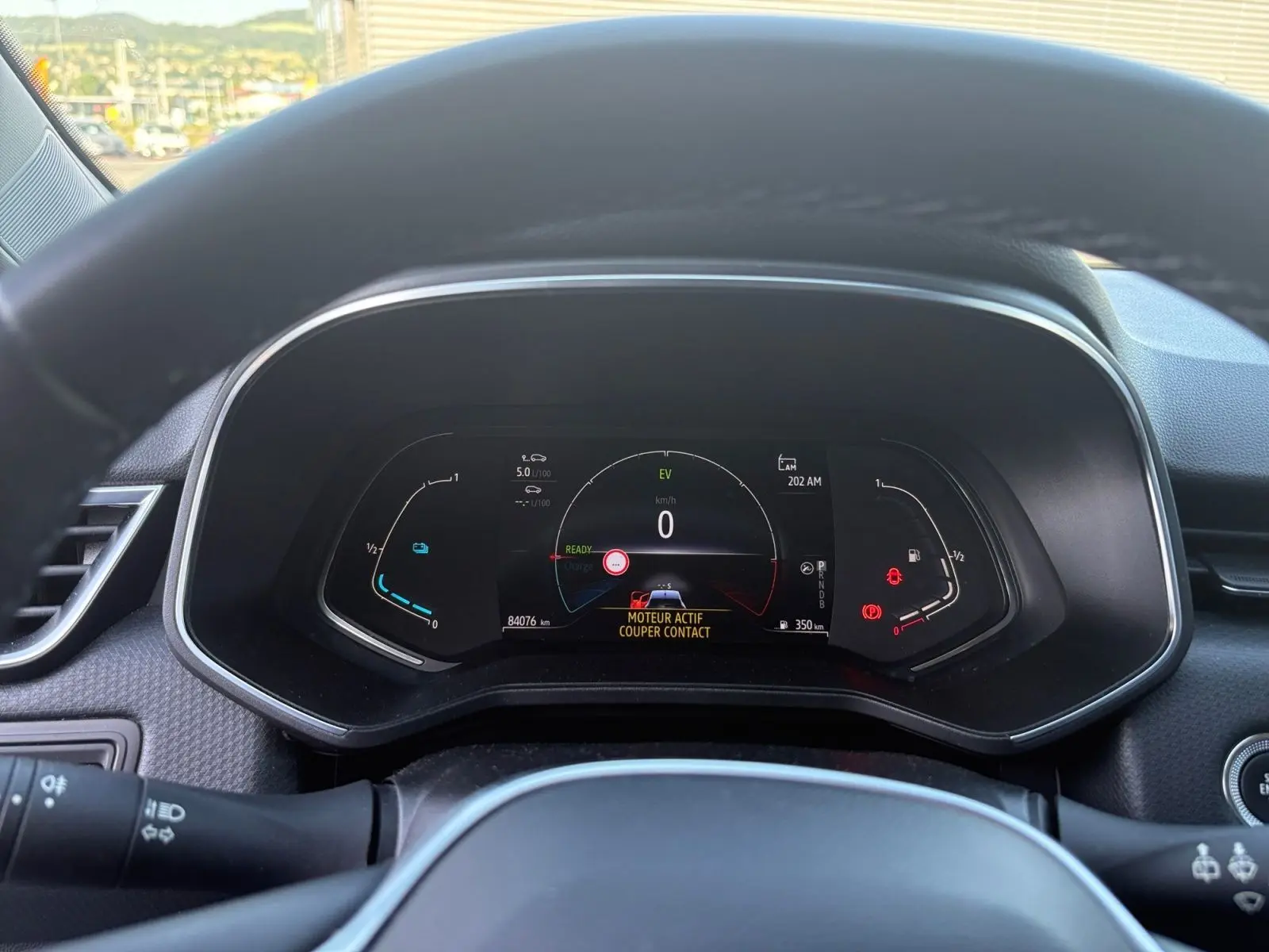 Vue rapprochée du tableau de bord numérique de la Renault Clio 1.6 E-TECH gris foncé, affichant les informations de conduite.