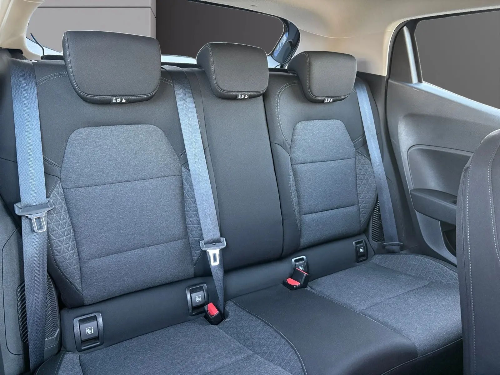 Vue intérieure de la banquette arrière en tissu gris foncé de la Renault Clio 1.6 E-TECH Business 2021, avec ceintures et appuie-têtes.