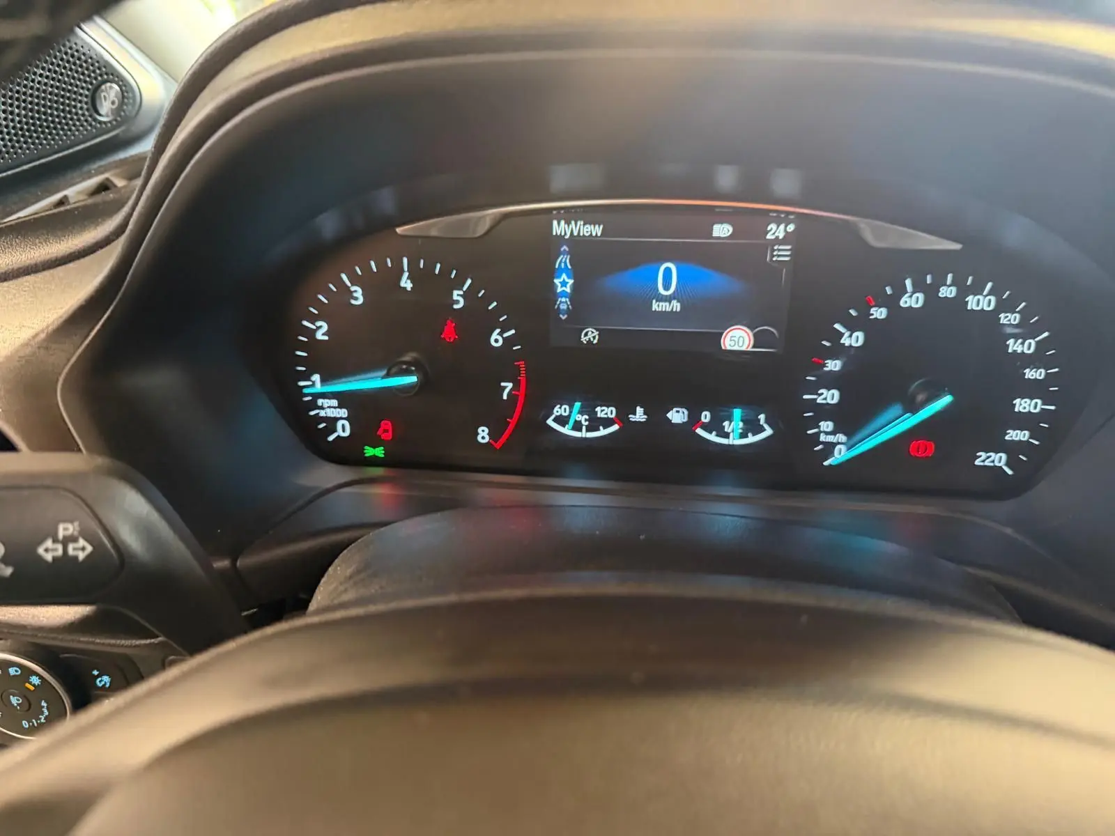 Vue rapprochée du tableau de bord numérique du Ford Puma gris 2021, affichant la vitesse à 0 km/h et divers indicateurs.