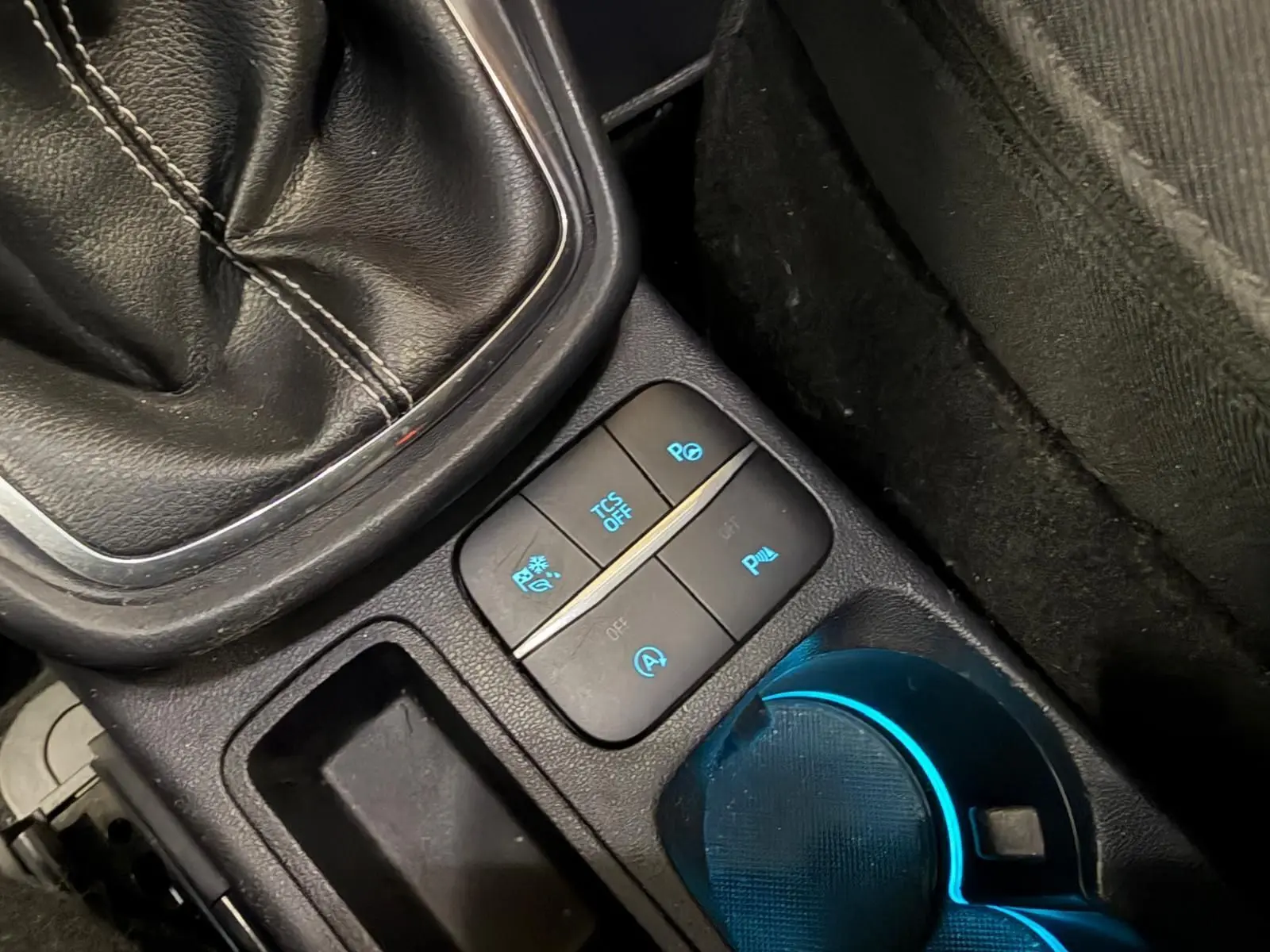 Gros plan sur la console centrale du Ford Puma gris 2021, montrant le levier de vitesse manuel et les boutons de contrôle éclairés.