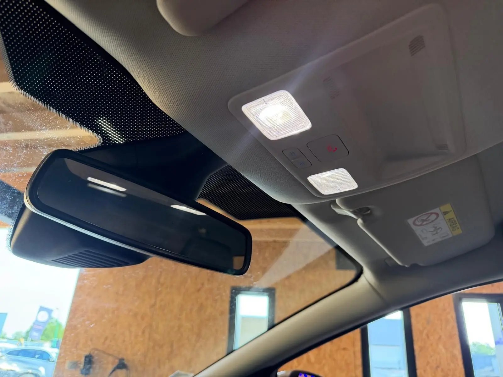 Vue intérieure du rétroviseur central et du plafonnier avec éclairage allumé d'une Ford Puma gris 2021 finition Titanium.