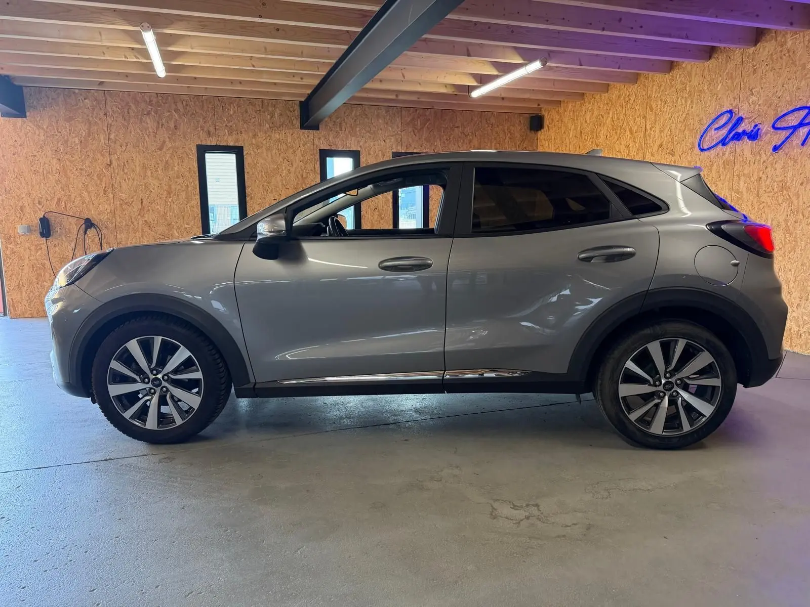 Vue de profil côté gauche d'un Ford Puma gris 2021 en version Titanium, avec jantes alliage et vitres teintées.