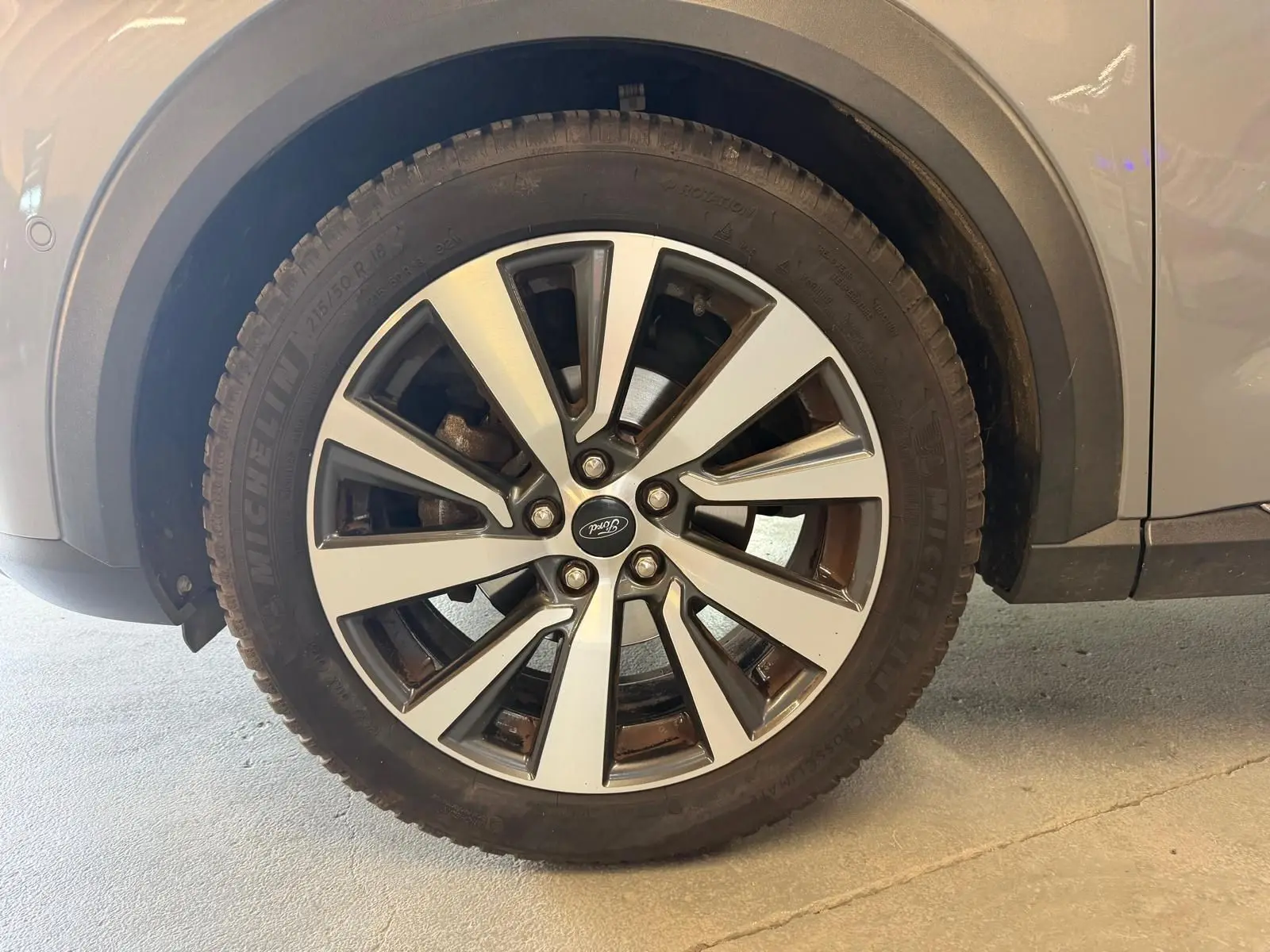 Gros plan sur la roue avant droite d’un Ford Puma gris, mettant en valeur la jante alliage à cinq doubles branches.