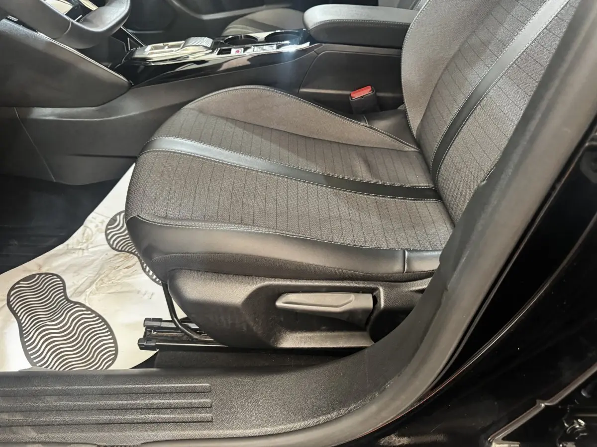 Vue intérieure côté conducteur du siège avant en tissu et cuir noir du Peugeot 2008 BlueHDi 130 de 2022.
