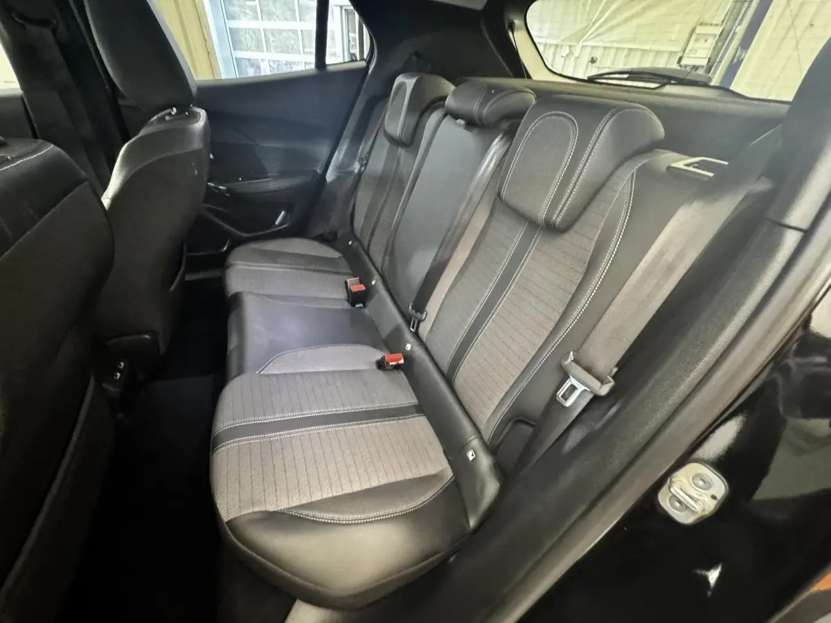 Vue intérieure côté droit montrant la banquette arrière bicolore en cuir et tissu du Peugeot 2008 noir.