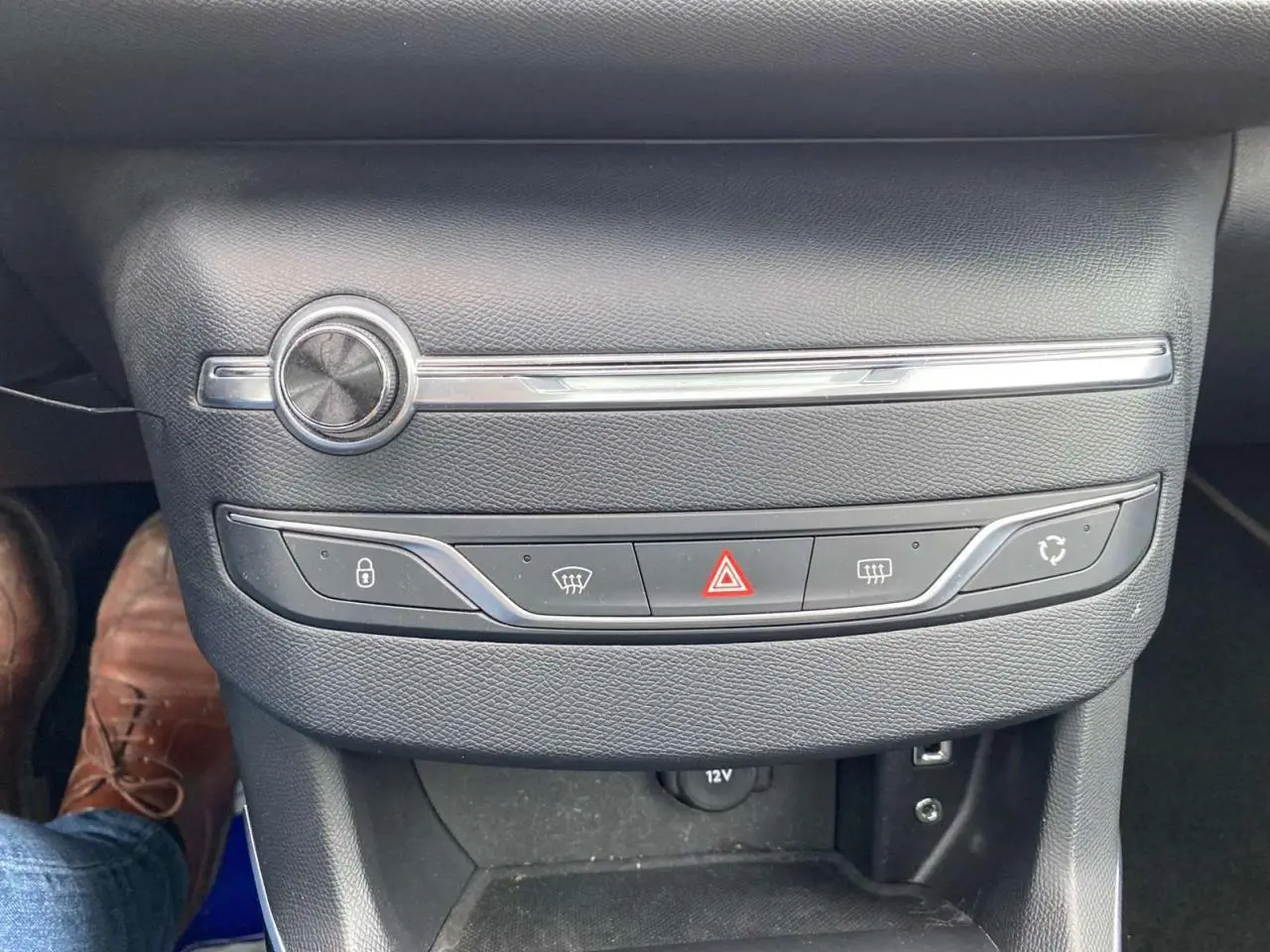 Vue rapprochée de la console centrale noire de la Peugeot 308 SW GT Line 2017 avec commandes de climatisation et bouton hazard.