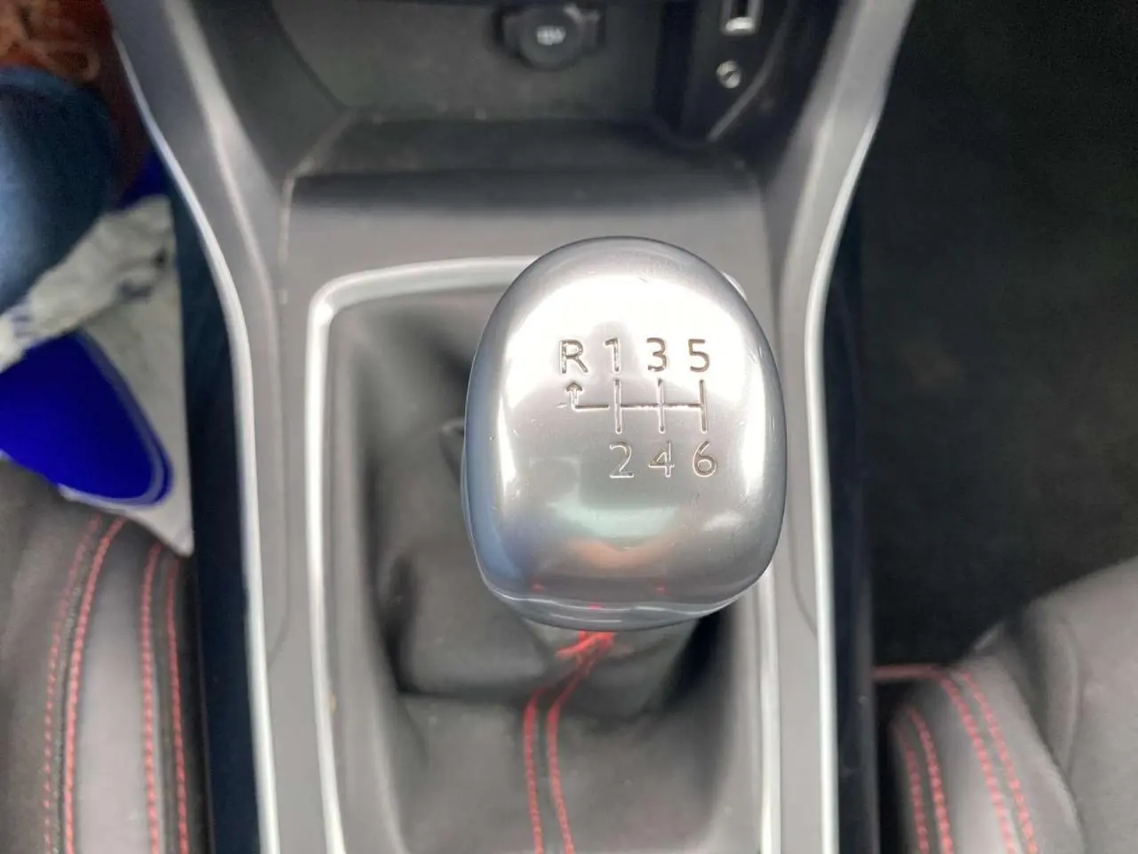 Le levier de vitesse manuel argenté de la Peugeot 308 SW GT Line 2017 avec surpiqûres rouges sur les sièges en tissu.