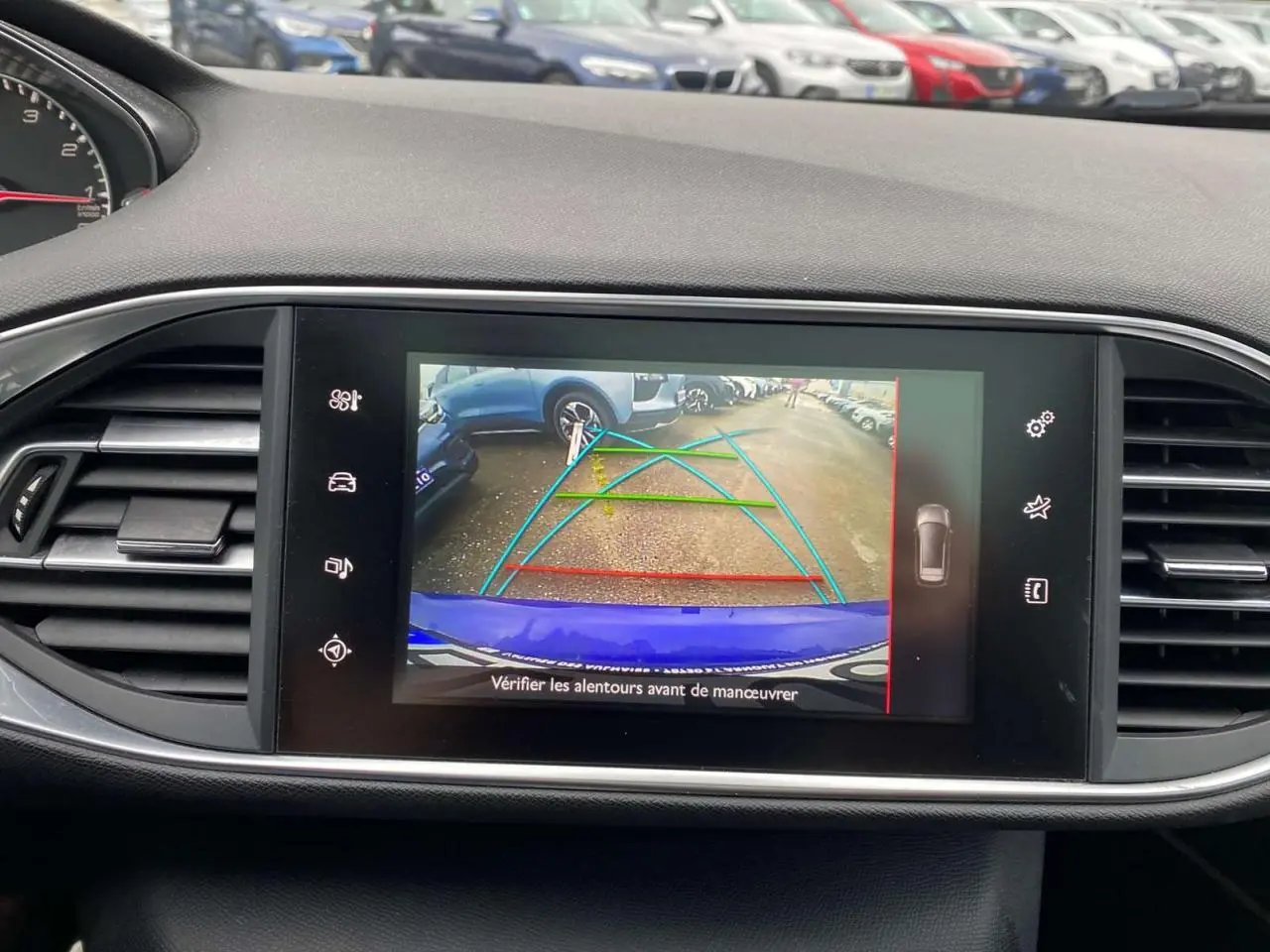 Vue de l'écran tactile de la Peugeot 308 SW bleu magnétique montrant la caméra de recul avec aides au stationnement.