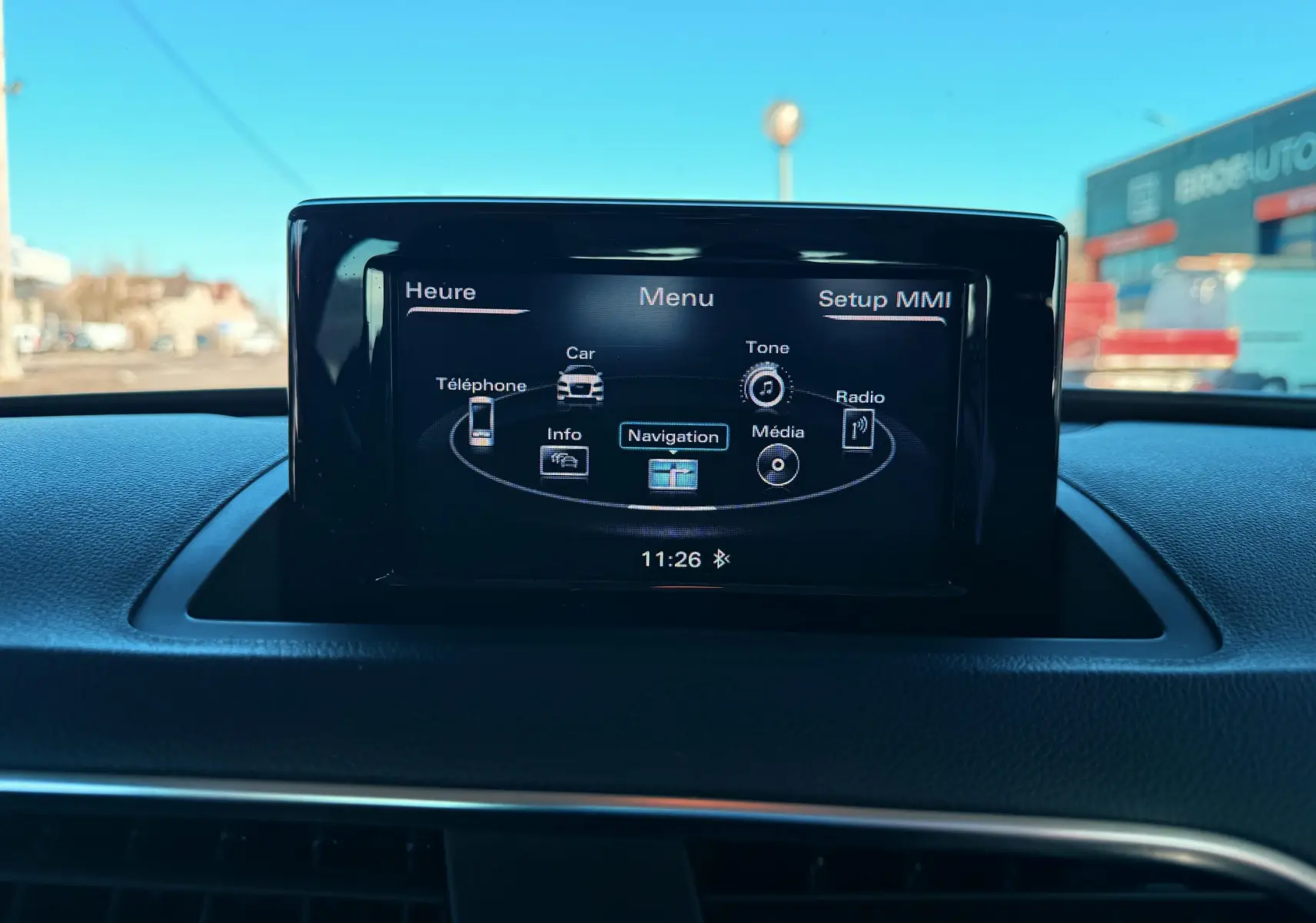 Écran central du système multimédia MMI de l'Audi Q3 2016, affichant le menu principal avec options de navigation et média.