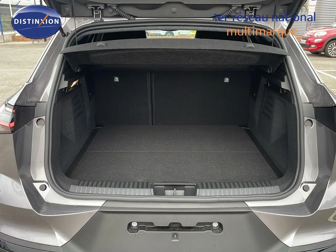 Coffre ouvert vu de l'arrière du Renault SYMBIOZ gris cassiopée métal, montrant un espace de chargement vide et spacieux.