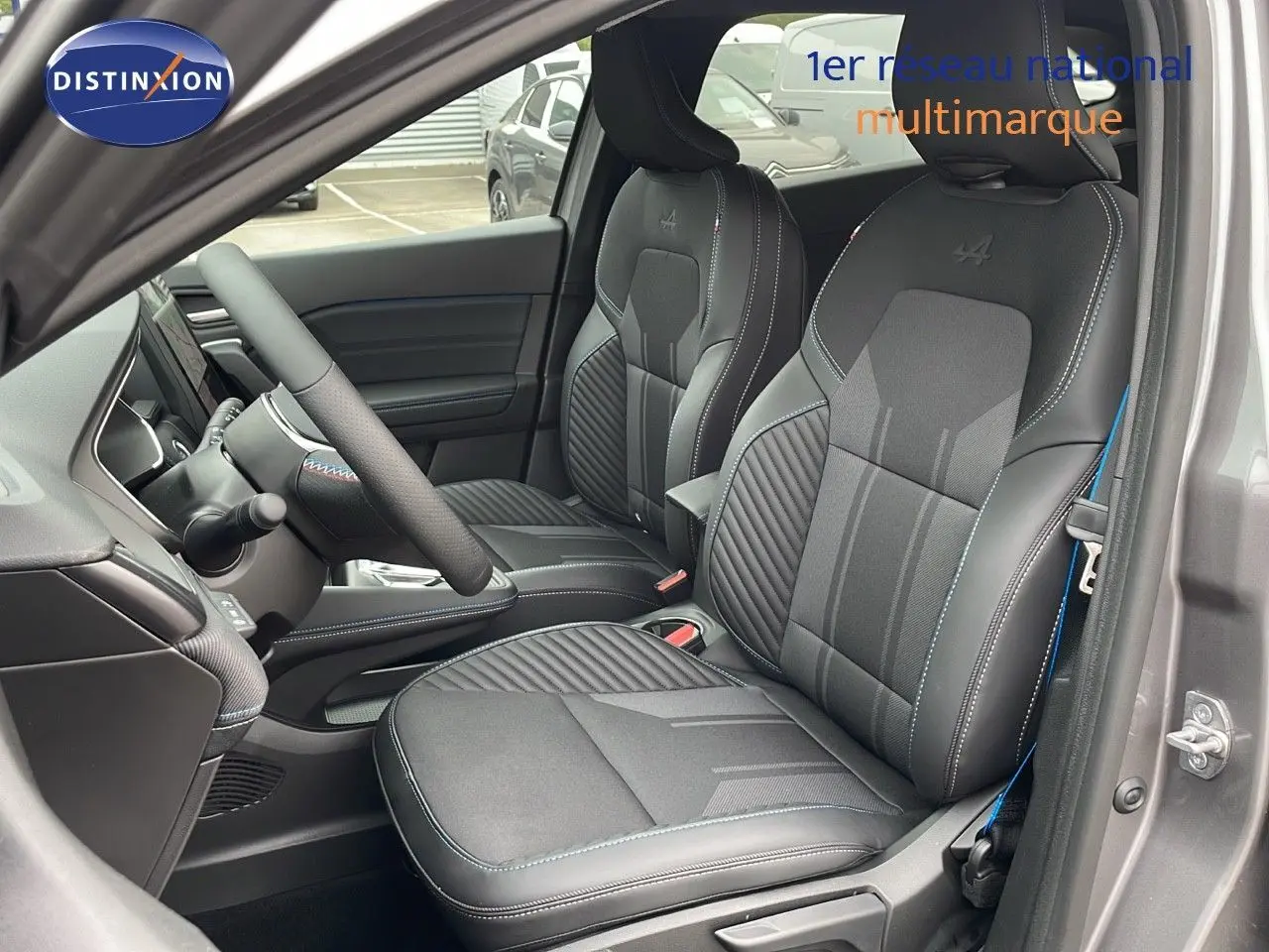 Vue intérieure côté gauche du Renault Symbioz 2025, sièges noirs avec surpiqûres bleues et logo Alpine brodé.