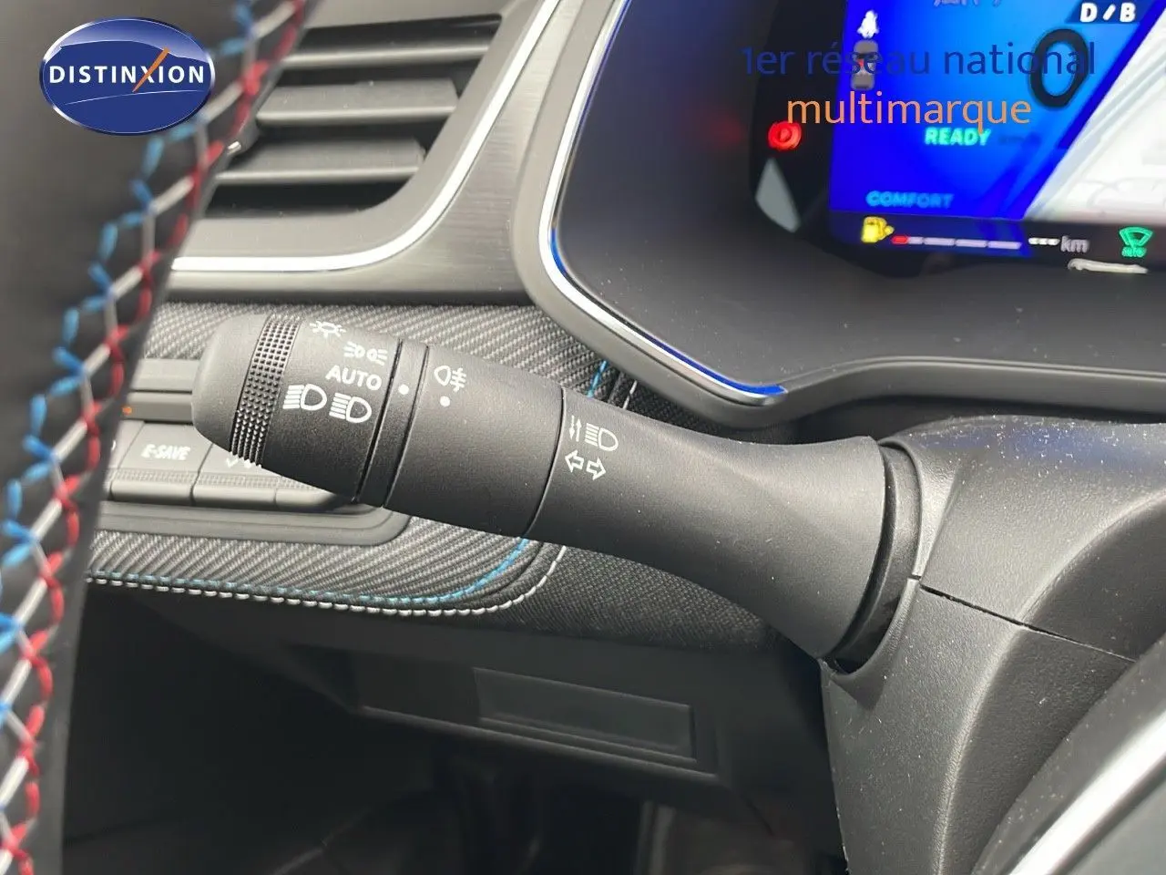 Gros plan sur la manette de commande d'éclairage à gauche du volant d'un Renault Symbioz gris cassiopée métal.