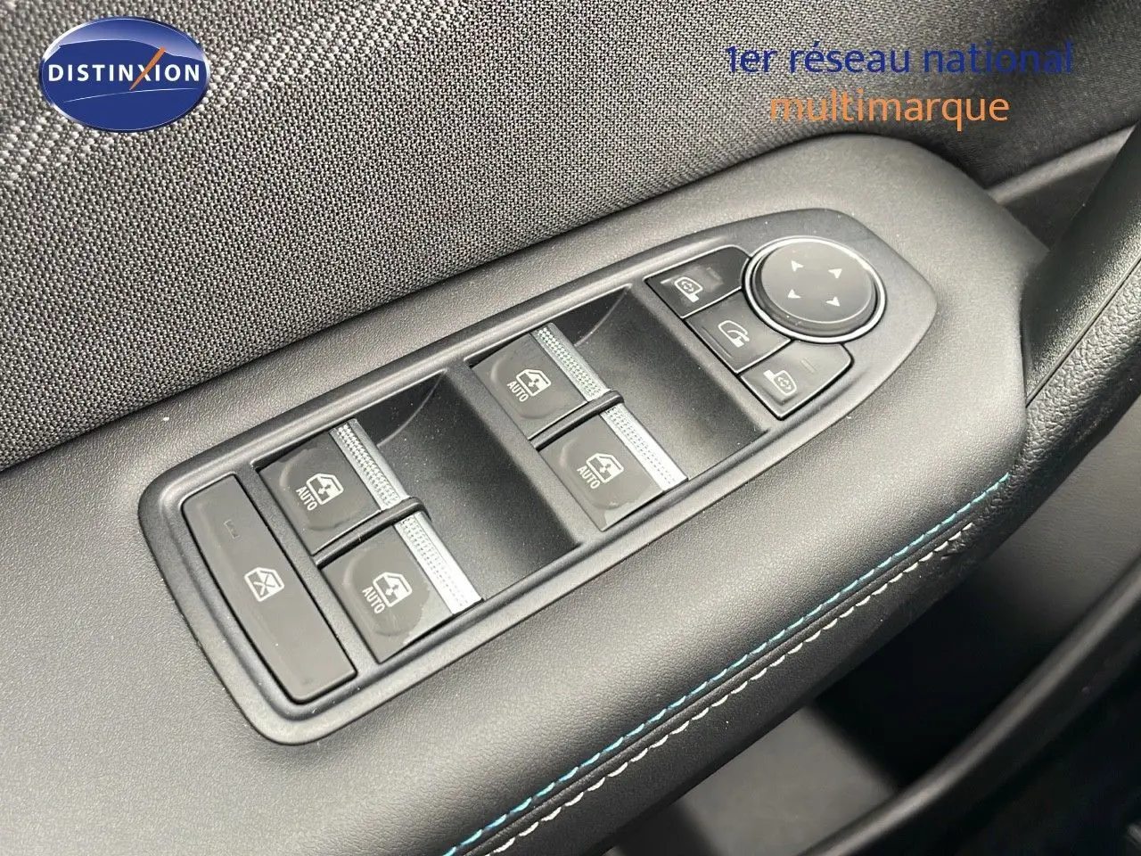 Gros plan sur les commandes de lève-vitres et rétroviseurs côté gauche d'une Renault Symbioz gris cassiopée métal.