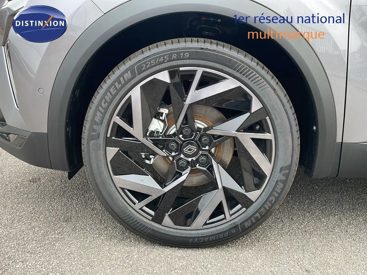 Gros plan sur la roue avant gauche du Renault Symbioz gris cassiopée métal, avec jante noire et argentée au design géométrique.