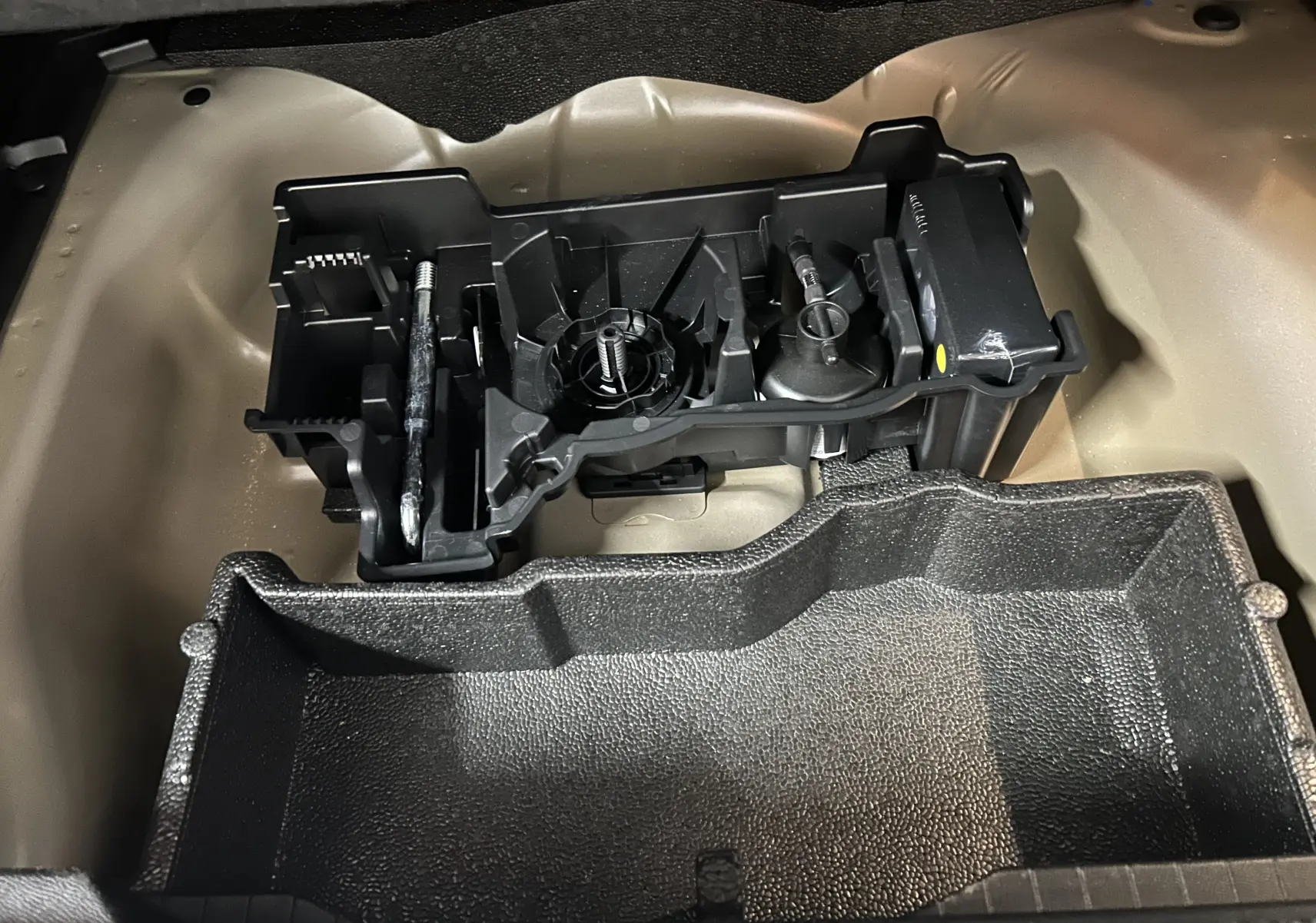 Vue rapprochée du coffre avec kit de dépannage pneumatique intégré dans un Peugeot 2008 Bleu Obsession 2025.