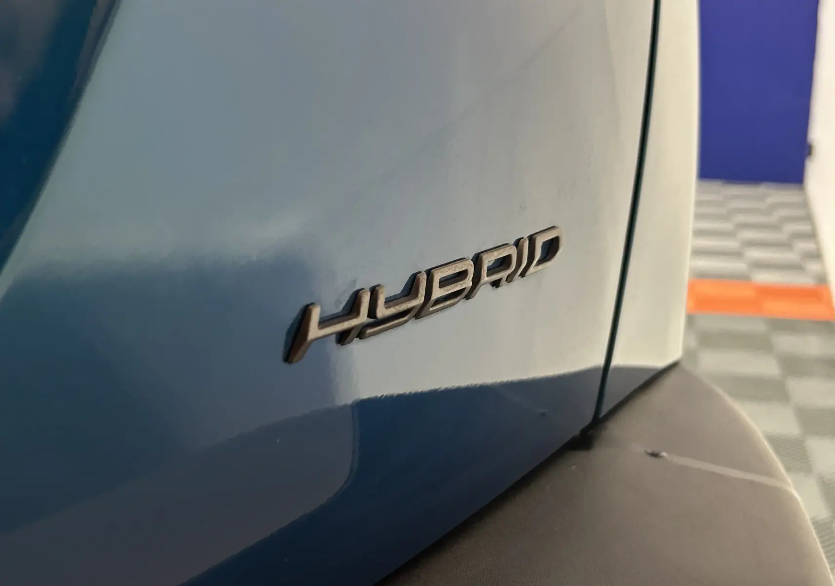Gros plan sur l’inscription "HYBRID" sur l’aile arrière droite d’un Peugeot 2008 Bleu Obsession.